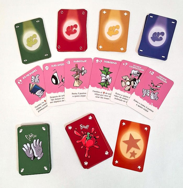 Las cartas pequeñas de la nueva edición: los reversos de color de cada jugador, un abanico de cartas de Acción y los mazos de Ovaciones y Abucheos